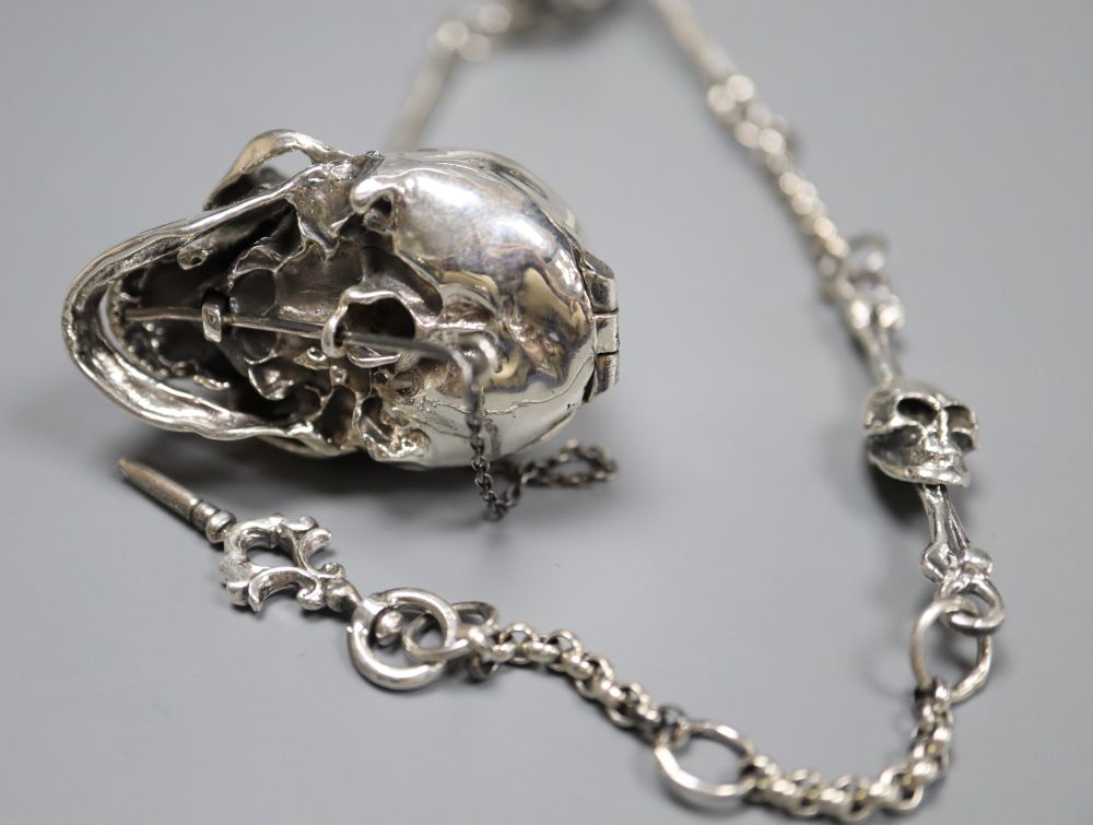 A sterling novelty skull locket?, on a skeletal albert chain, 32.5cm, gross 54 grams.